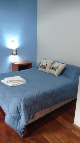 a blue bed with two pillows on top of it at Apartamento céntrico Campana in Campana