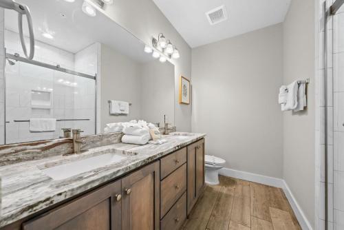 a white bathroom with a sink and a toilet at Hammock Dunes J by Youngs Suncoast in Orange Beach