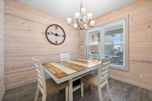 a dining room with a table and chairs and a clock at Hammock Dunes J by Youngs Suncoast in Orange Beach