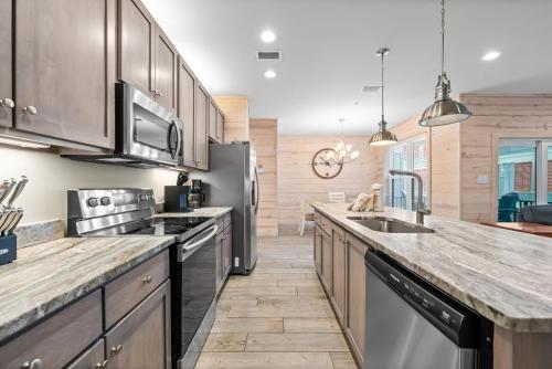 a kitchen with stainless steel appliances and wooden cabinets at Hammock Dunes J by Youngs Suncoast in Orange Beach