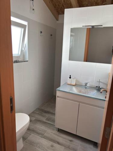 a bathroom with a sink and a toilet and a mirror at Casa da Roda in Arronches