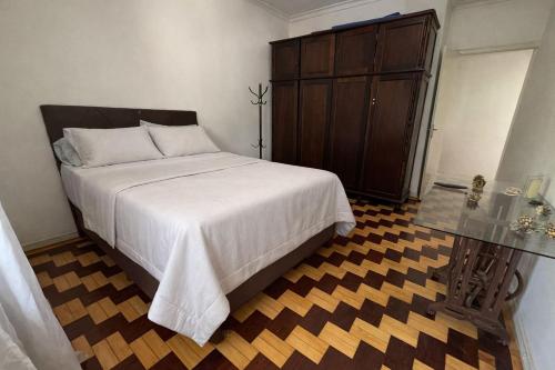 a bedroom with a bed and a wooden cabinet at Apto Pet Friendly com Ar condicionado no Centro in Bagé