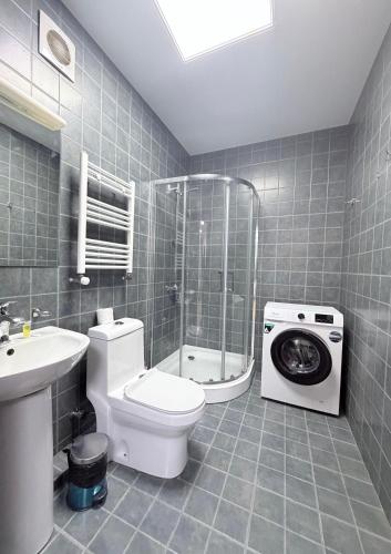 a bathroom with a toilet and a washing machine at Hotel All Time in Tbilisi City