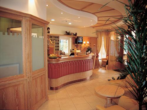 a bar in a restaurant with a counter and a table at Hotel Comfort Erica Dolomiti Val d'Adige in Salorno sulla Strada del Vino