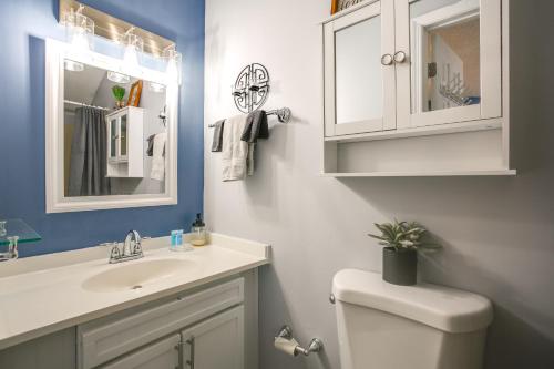 a bathroom with a toilet and a sink and a mirror at Steps to Brigantine Beach: New Jersey Beach Condo in Brigantine