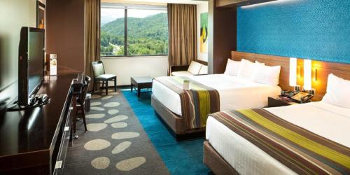 a hotel room with two beds and a television at Harrah's Cherokee Casino Resort - A Caesars Rewards Destination in Cherokee