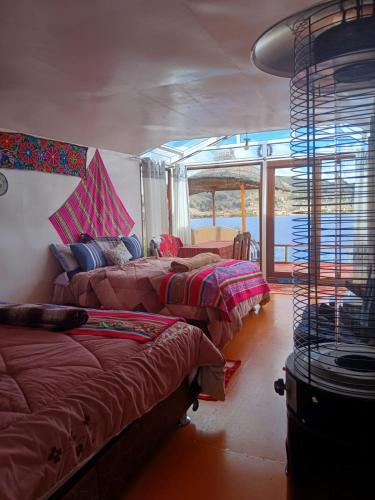 a room with three beds in a room with a window at Wiñay UTA lodge in Puno