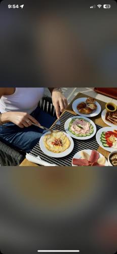 a person sitting at a table with plates of food at Khufu pyramids boutique hotel in ‘Ezbet `Abd el-Ḥamîd
