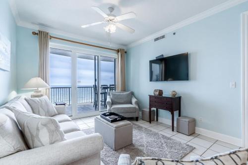 a living room with a couch and a tv at Island Royale 1004 by Youngs Suncoast in Gulf Shores