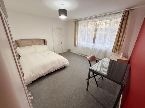 a bedroom with a bed and a desk and a table at Precious House 4 in Leicester
