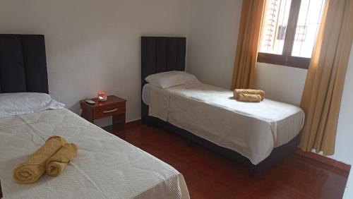 ein Schlafzimmer mit zwei Betten und einer Kerze auf einem Tisch in der Unterkunft Descanso Perfecto Ruta 34, Wifi, Cochera e Ideal para Viajeros, 3 personas in Fernández