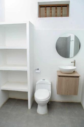 a bathroom with a white toilet and a sink at SGH Hotel San Agustin in Santa Marta