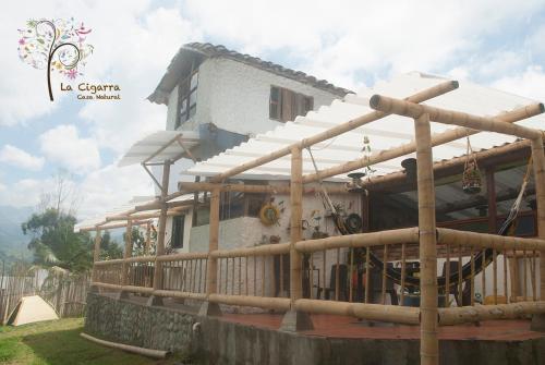 a house with a wooden fence around it at La Cigarra Casa de Huéspedes in Salento