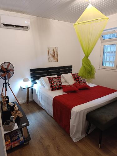 a bedroom with a large bed with red and green pillows at DADI'S LITTLE PARADIS in Sainte-Rose