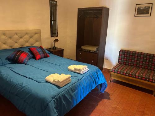 a bedroom with a blue bed with towels on it at Chalet Doña Ines in Cuesta Blanca