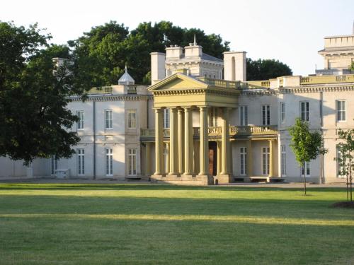 a large white house with columns on the lawn at Signature Stay Inn & Suites - Downtown Hamilton in Hamilton