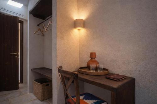 a room with a table with a vase on it at Masseria Guadalupe, The Mascienda in Ostuni