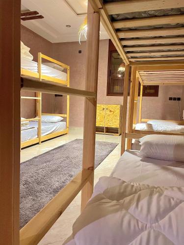 a room with two bunk beds and a room with a hallway at Tayri Surf House Aourir in Agadir