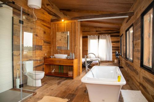 a bathroom with a tub and a toilet and a sink at Villa Aïdo in Ouidah