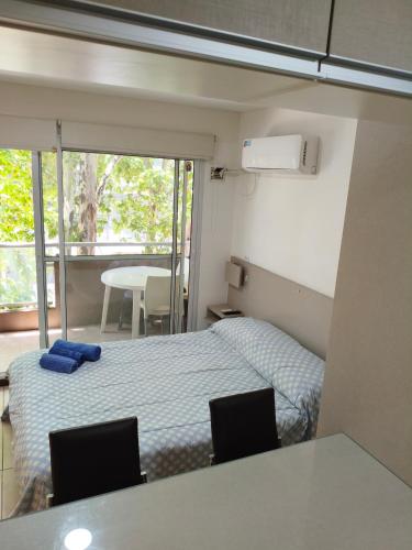 a small bedroom with a bed and two chairs at Alojamiento Premium en Pichincha in Laprida