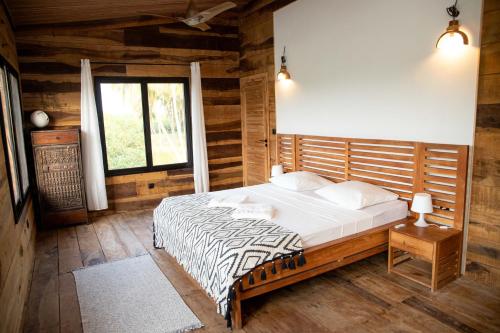 a bedroom with a bed in a wooden room at Villa Aïdo in Ouidah