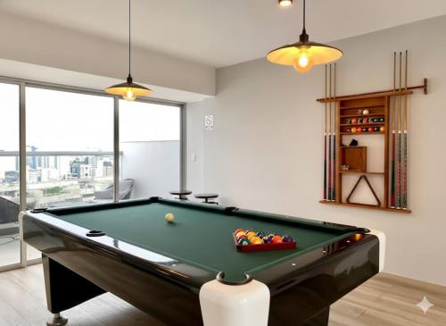 a billiard room with a pool table and windows at Barranco Modern Apartments with Rooftop Pool by Geko in Lima