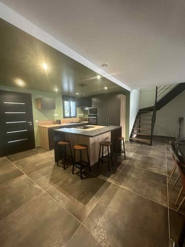 Maisoncp27 في Ponts-et-Marais: مطبخ به جزيرة كبيرة مزودة بمقاعد