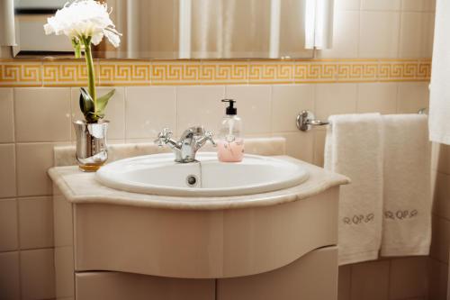 a bathroom with a sink and a vase of flowers at Quinta do Pinheiral in Favões