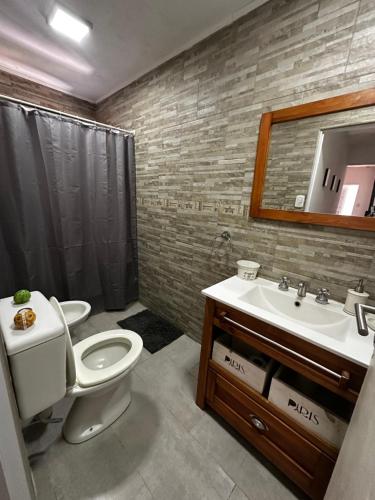 a bathroom with a toilet and a sink and a mirror at El descanso in Ramallo