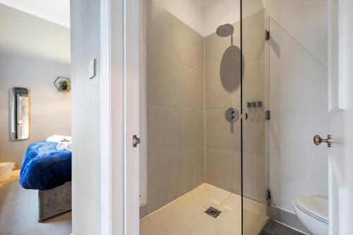 a shower with a glass door in a bathroom at Premium Beach Front with Balcony! 2 En-Suites & Spacious By Stay Aura Vacation Rental Brighton & Hove in Brighton & Hove