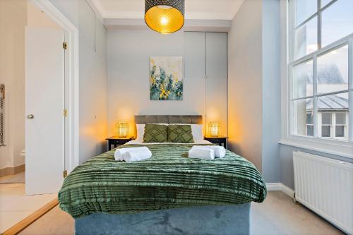 a bedroom with a large bed with two towels at Premium Beach Front with Balcony! 2 En-Suites & Spacious By Stay Aura Vacation Rental Brighton & Hove in Brighton & Hove