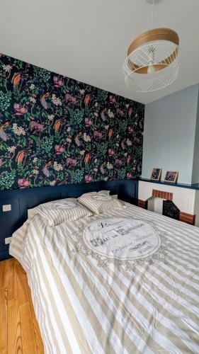 a bedroom with a large bed with a floral wallpaper at Le Saint-Georges in Berck-sur-Mer
