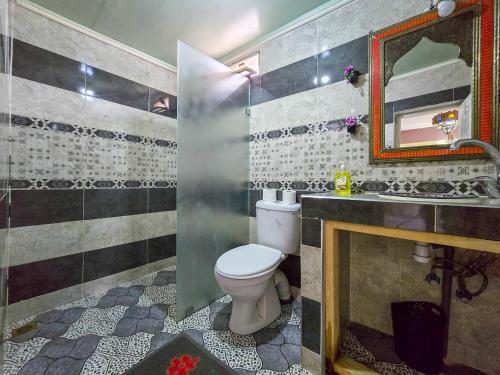 a bathroom with a toilet and a sink and a mirror at Riad Fes Hayat - Confort Stay in Fez