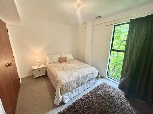 a small bedroom with a bed and a window at St Okes Apartment- Peaceful retreat set in native bush Stay 1 night, 1 week or 1 month in Lower Hutt