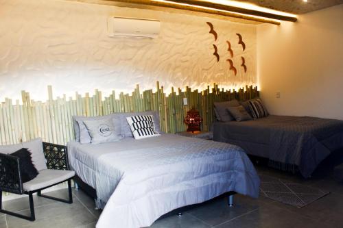 a bedroom with two beds and a wall with birds on it at Chalé São Bernardo, Carmo RJ in Carmo