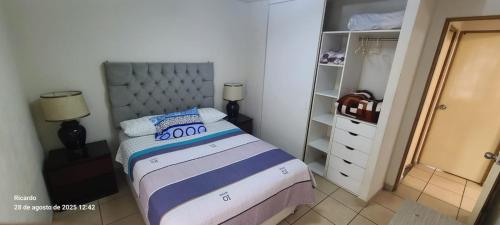 a small bedroom with a bed and a closet at Departamento Centenario in Lima