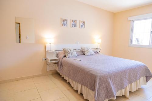 a bedroom with a large bed with two lamps at Departamentos Valle de los Andes in San Rafael