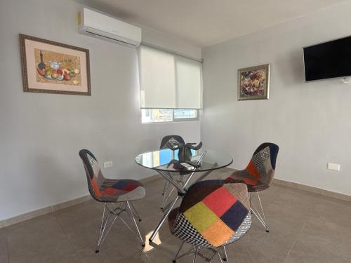 a dining room with a glass table and chairs at Mi lugar en Merida in Mérida