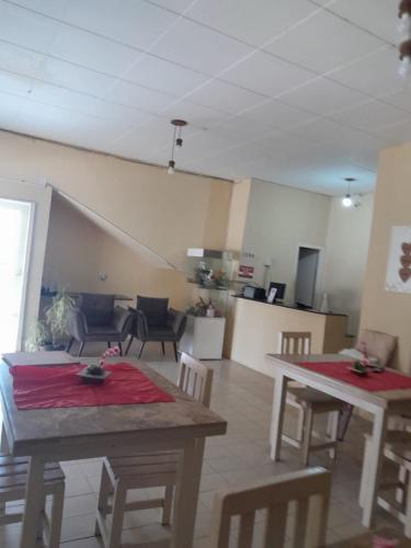 a room with two tables and chairs and a kitchen at Pousada Umari in Salgueiro