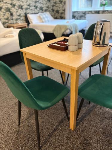 a wooden table with green chairs and a telephone on it at Piccolo in Glasgow