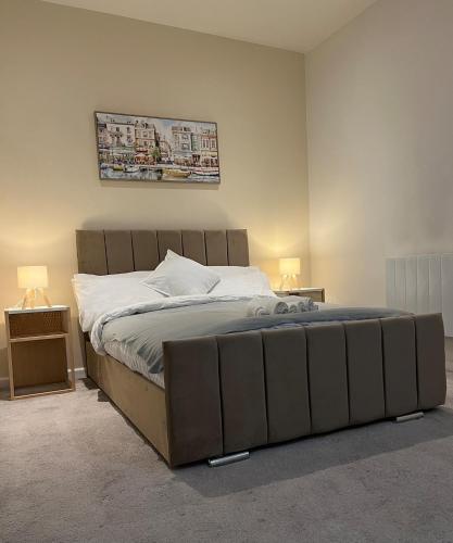a large bed in a bedroom with two lamps at New & Modern 2-Bed Flat in City Centre in Nottingham