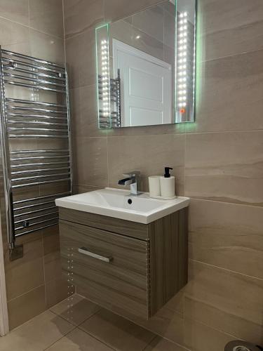 a bathroom with a sink and a mirror at New & Modern 2-Bed Flat in City Centre in Nottingham