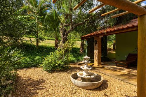 a stone fountain in the middle of a yard at Pousada Morada do Paraíso in Torrinha