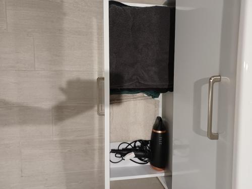 a closet with a door with a black towel at Le Doudou, Charmant T2 avec Terrasse et Climatisation in Marmande