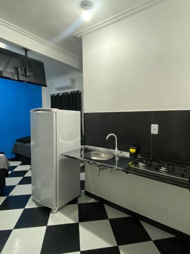 a kitchen with a black and white checkered floor at Residencial Monteiro Luna in Benevides