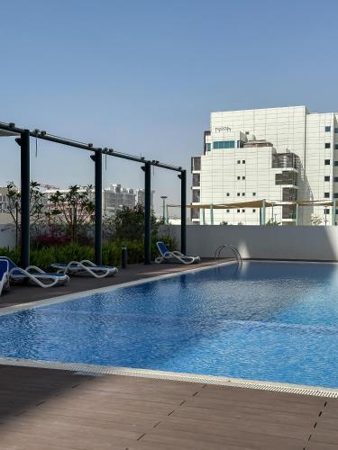 a swimming pool on the roof of a building at 2BR Duplex in Masdar 5 Mins to Abu Dhabi Airport in Abu Dhabi
