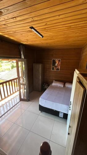 a bedroom with a bed in a wooden ceiling at canto da lagoa in Garopaba