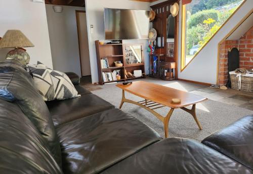 a living room with a couch and a coffee table at Greenstone Panorama - Family Bach - Stunning Views in Queenstown