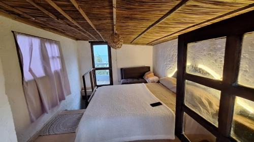 a bedroom with a bed and a window at Eywa in Punta Del Diablo