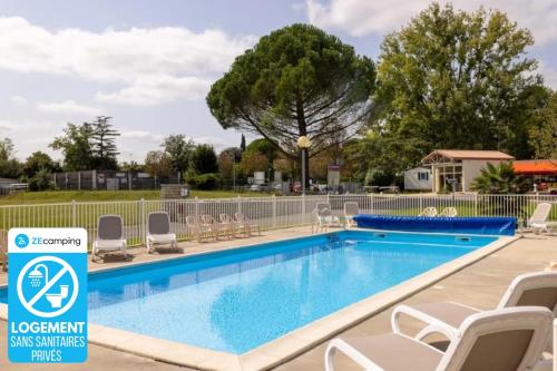a swimming pool at a resort with chairs and a fence at ZEcamping 3 animaux acceptés piscine et restaurant in Saintes